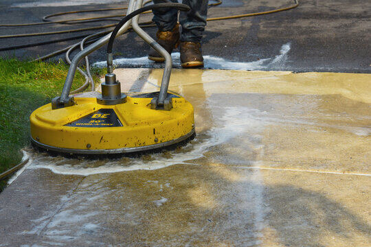 Industrial surface cleaner pressure washing a commercial concrete sidewalk